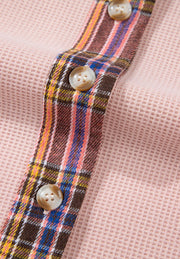 Blush pink waffle knit shacket with plaid trim and button detail.
