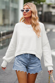 White ribbed knit batwing sweater with crew neck and cropped length.