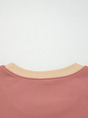 Dusty pink sweatshirt with contrast tan ribbed crewneck and exposed seams.
