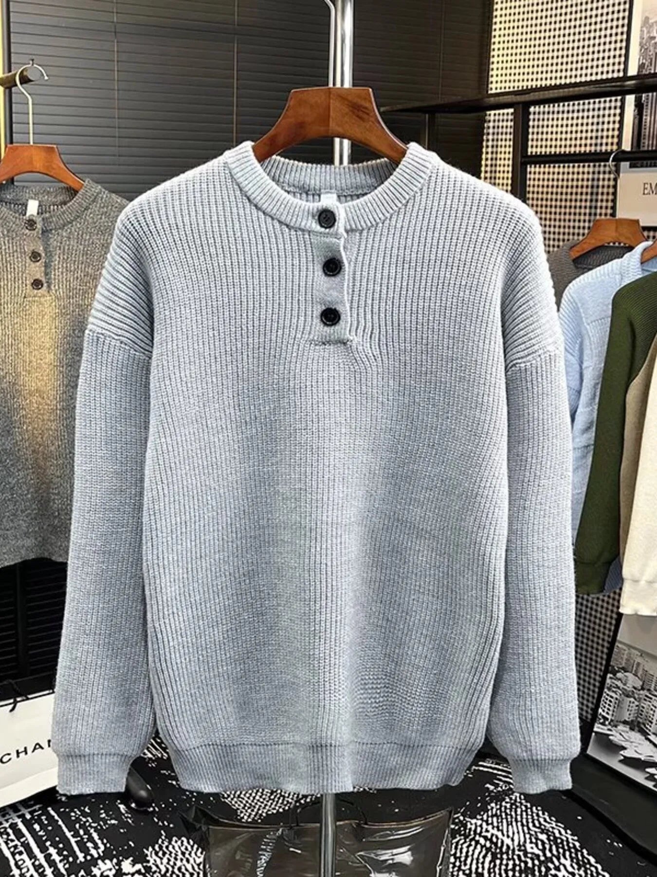 Light gray ribbed knit sweater with button detail at the neckline.