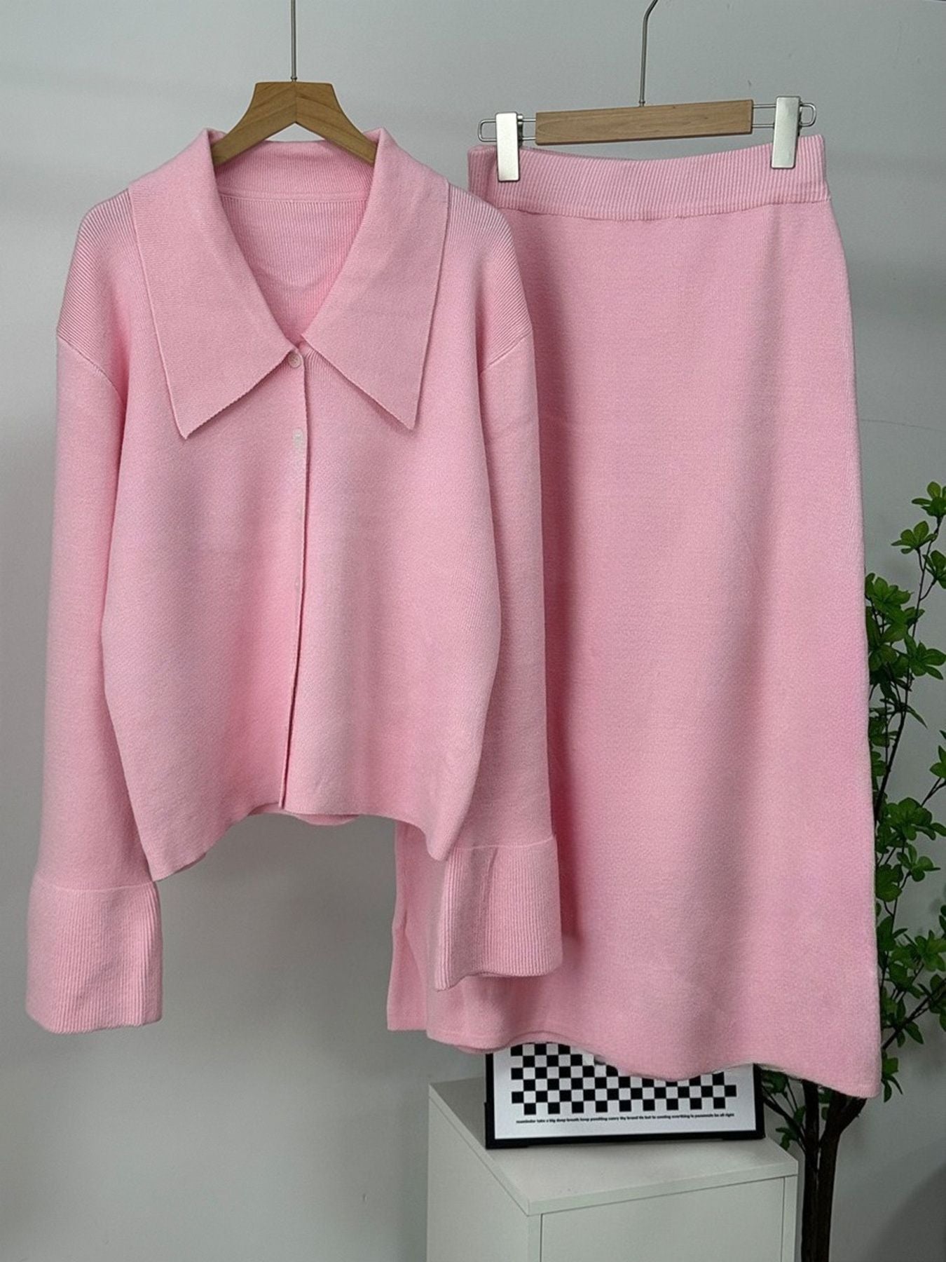 Pink ribbed knit cardigan with collar and button-down front, paired with a matching knit skirt.