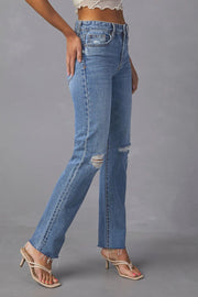 Medium wash distressed straight leg denim jeans with ripped knees and frayed hem.
