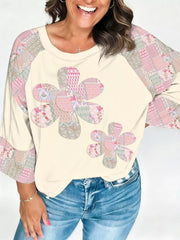 Cream long-sleeve shirt with floral patchwork on the front and sleeves, crew neck.
