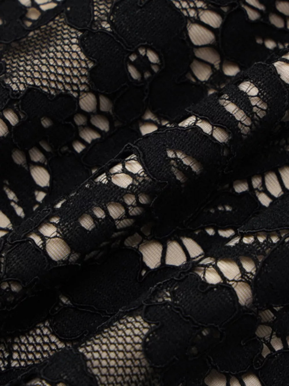 Black lace mini dress detail with spaghetti straps and floral pattern