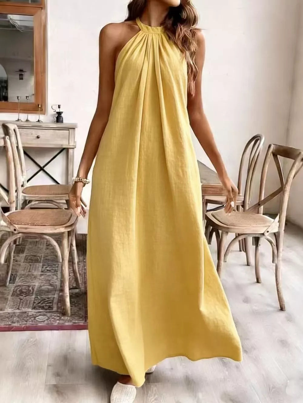 Yellow ruched halter maxi gown with flowing skirt.