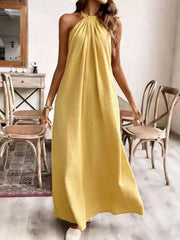 Yellow ruched halter maxi gown with flowing skirt.