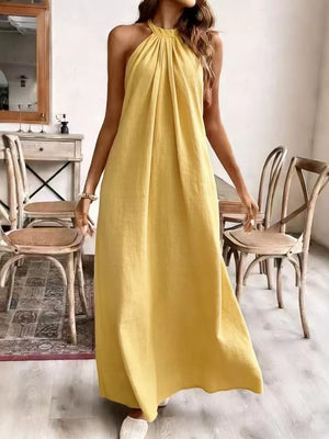 Yellow ruched halter maxi gown with flowing skirt.