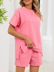 Pink relaxed two-piece set with short sleeves, crew neck, and shorts with pockets.