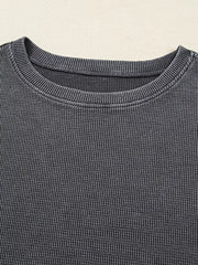 Textured dark gray waffle knit oversized sweatshirt with crew neck.