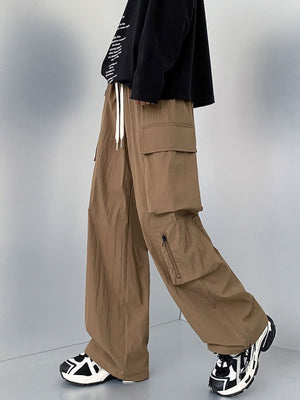 Men's camel cargo sweatpants with drawstring and zippered pockets.