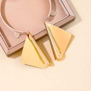 Gold sculptural triangle earrings with a polished finish.