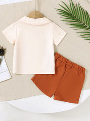 Baby boys' set: cream collared short-sleeve shirt and burnt orange shorts.