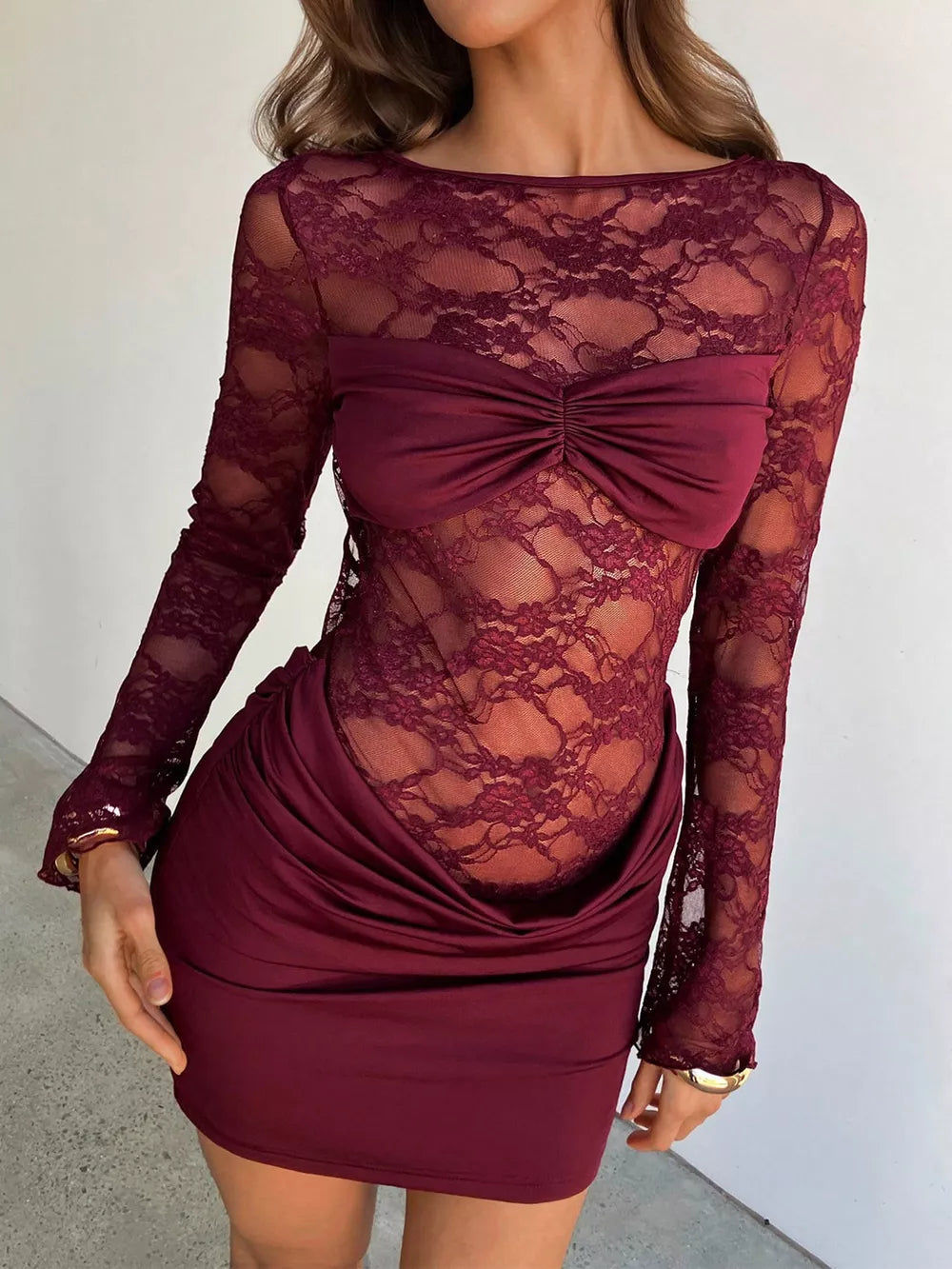 Burgundy lace backless ruched mini dress with long sleeves and draped skirt.