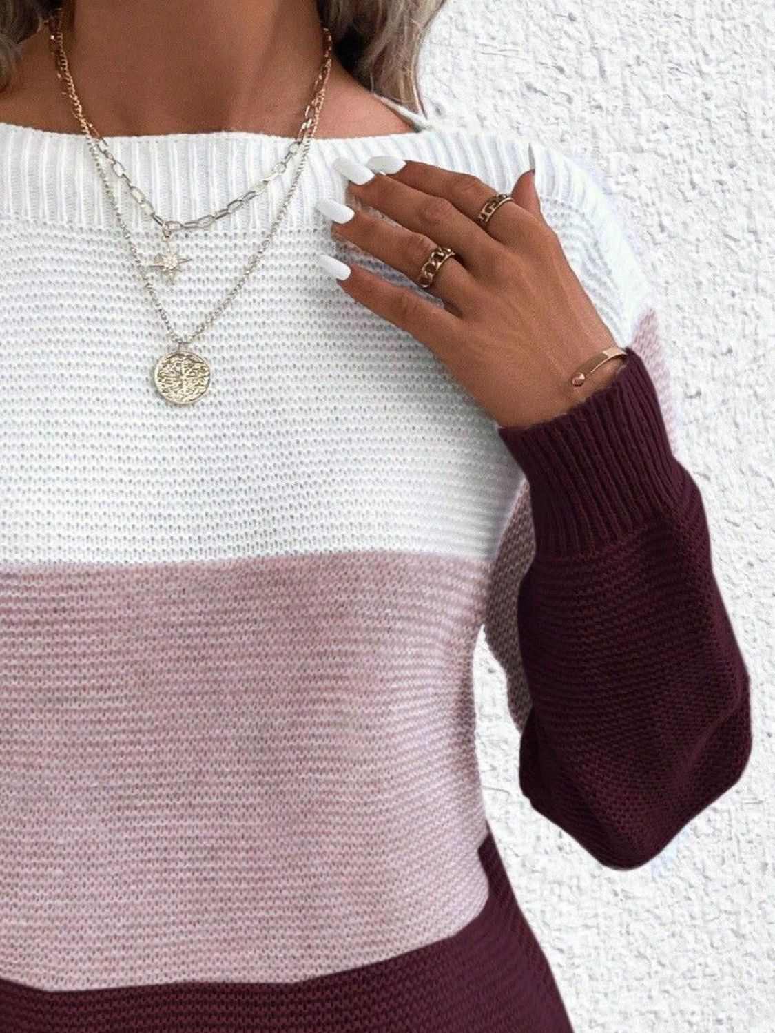 Colorblock ribbed knit sweater with boatneck and burgundy sleeves.