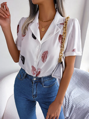 White feather print collared puff sleeve blouse with button front and rolled cuffs.