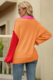 Colorblock knit pullover sweater with orange, hot pink, and red panels and a collared neckline.