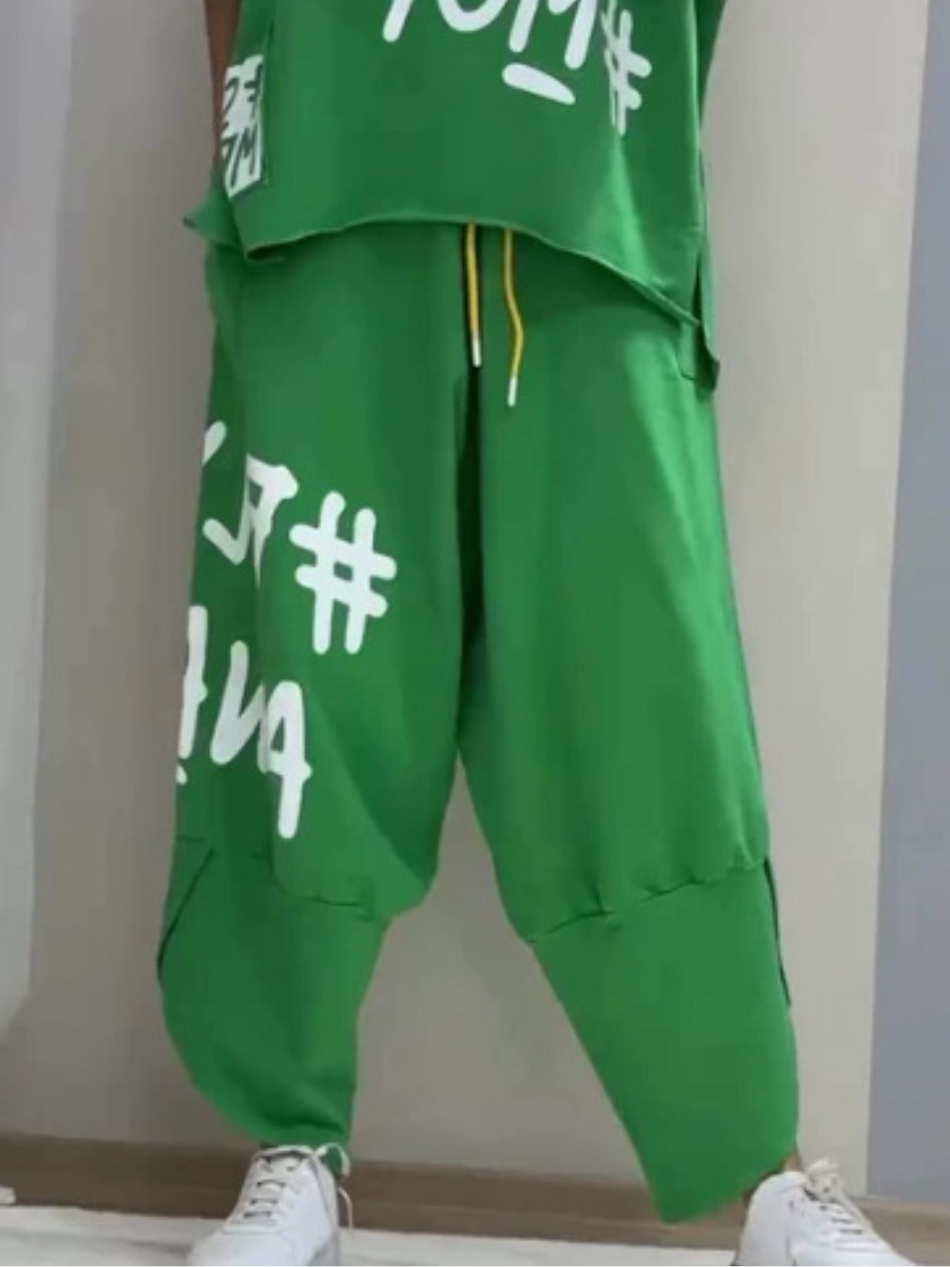 Green graphic tee and drawstring pants set with white lettering and yellow drawstrings.