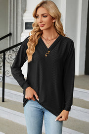 Black textured henley v-neck top with button detail and long sleeves.