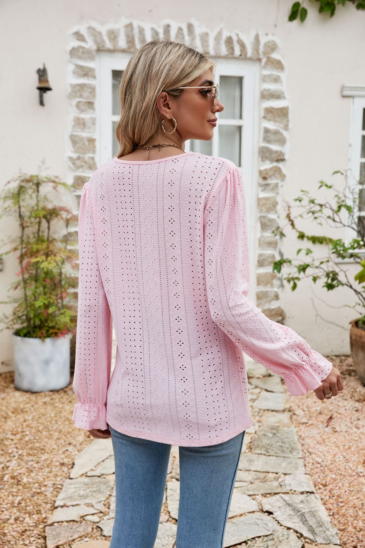 Blush pink eyelet lace blouse with ruffle sleeves and cuffs.