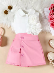 Pink skort with decorative buttons and white sleeveless collared top with floral applique and ruffles.