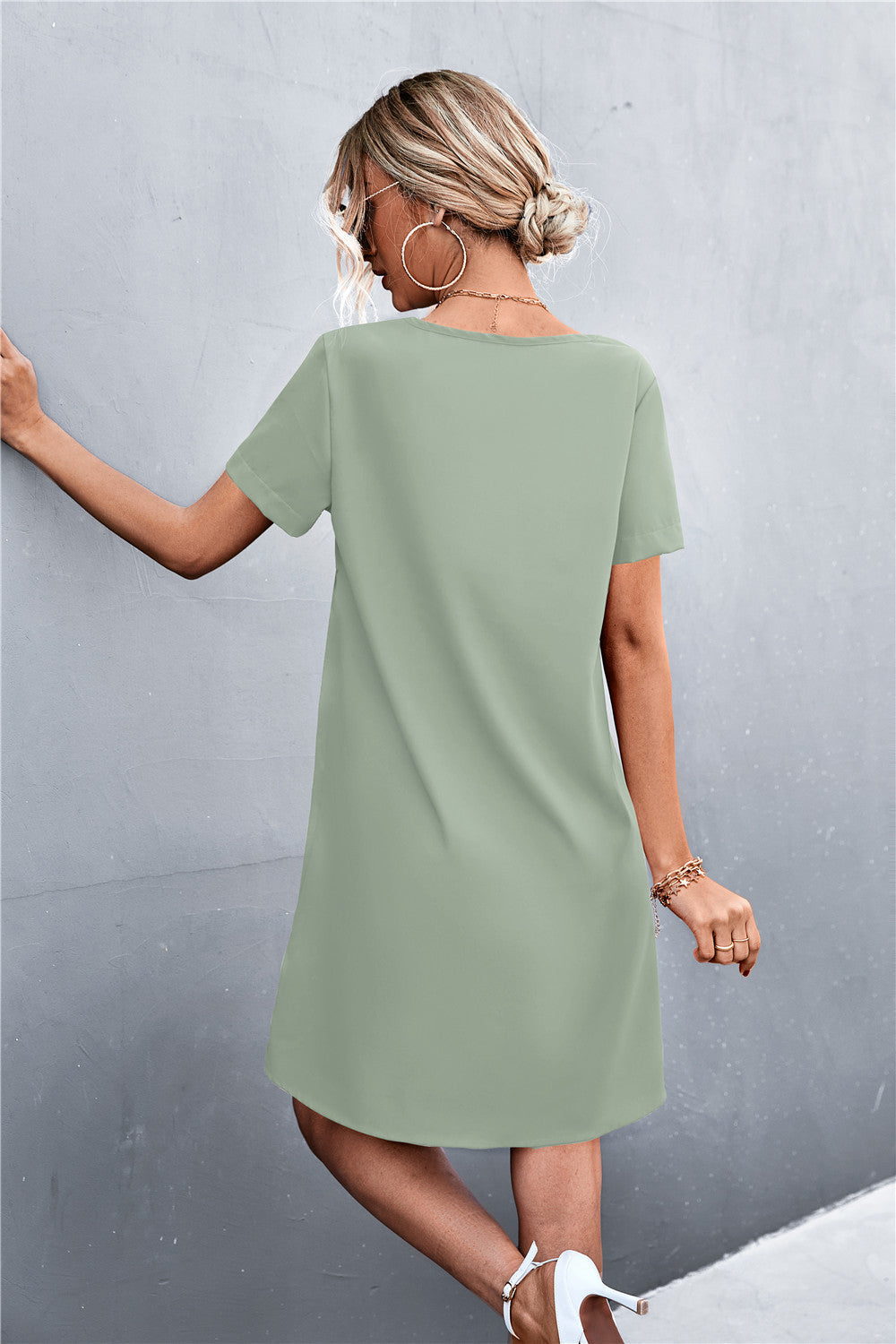 Green V-neck shift dress with short sleeves and lace trim detail.