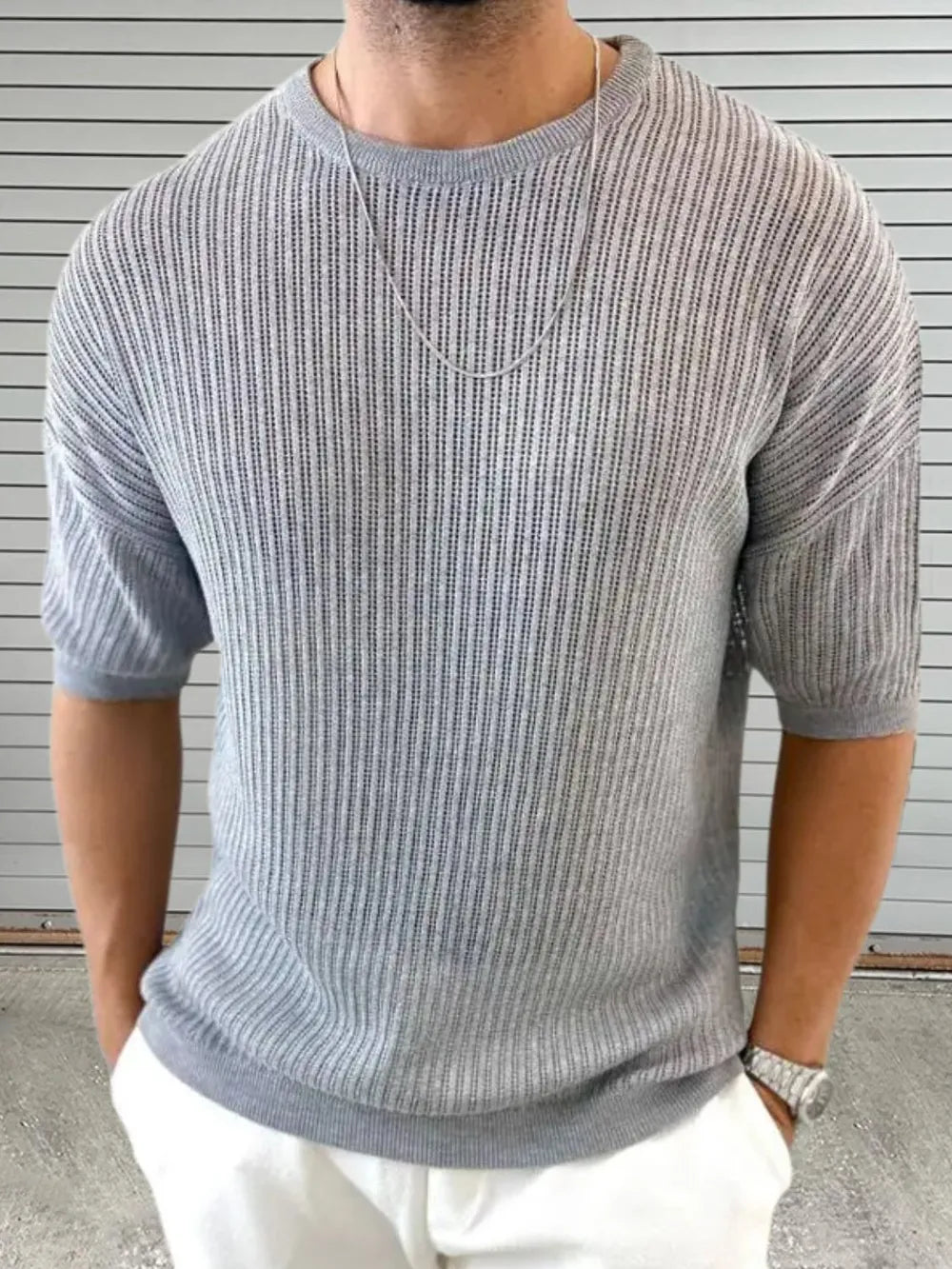 Gray open-knit sweater with boxy sleeves and a crew neck.