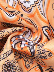 Paisley print ruched halter top in tangerine with black and white details.