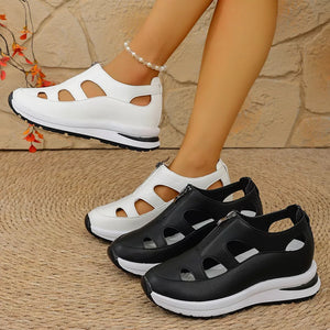 Chic cutout wedge sneakers in black and white with zipper detail and chunky sole.