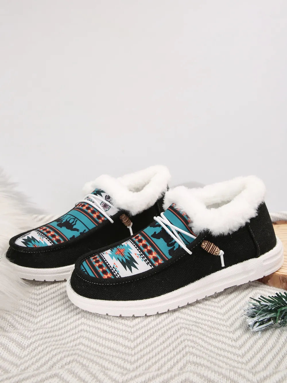Southwestern print faux fur lined loafers in black with white laces and wooden toggles.