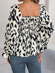 Smocked bodice square neck blouse in black and cream animal print with long sleeves.