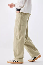 Men's relaxed fit sage cotton jeans with drawstring waist and back pocket detail.