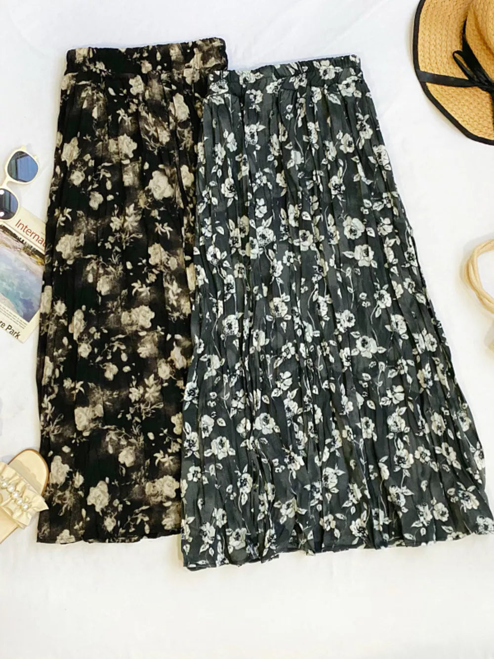 Botanical pleated midi skirts in black and taupe with a crinkled texture.