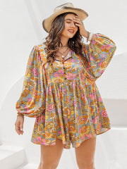 Babydoll romper in light blue with a vibrant bohemian floral print, button front, and balloon sleeves.