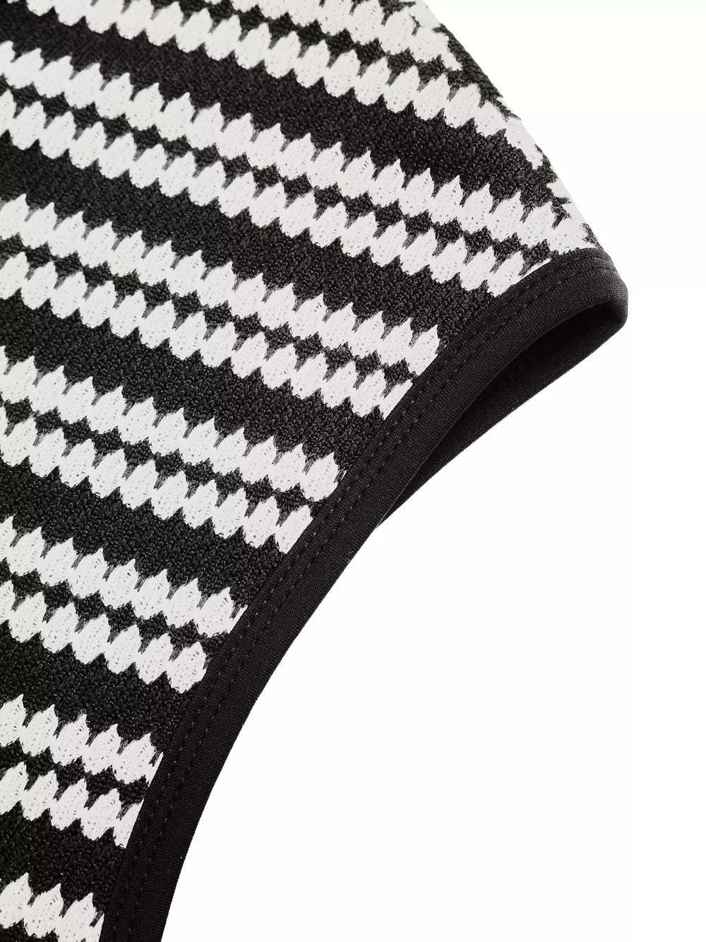 Black and white houndstooth knit maxi dress detail with black trim.