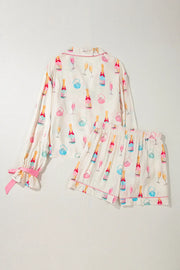 Champagne print silk pajama set in white with pink trim and bow details on sleeves.
