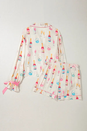Champagne print silk pajama set in white with pink trim and bow details on sleeves.