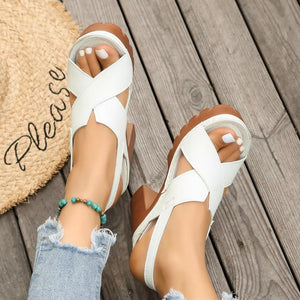 White open toe block heel sandals with criss-cross straps and a chunky sole.