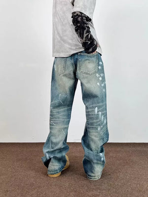 Men's blue 100% cotton wide leg jeans with paint splatters and distressed details.