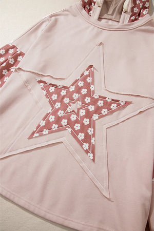 Dusty pink hoodie with floral star patchwork and raw hem details.
