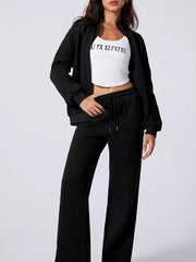 Black cotton joggers with drawstring waist and zip-up jacket.