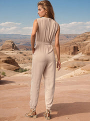 Tan draped wrap jumpsuit with jogger cuffs and belted waist.