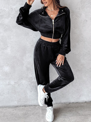 Black velvet crop tracksuit with zipper detail and elastic cuffs.