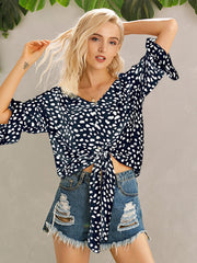 Dark blue spotted knot-front blouse with flared sleeves and button detail