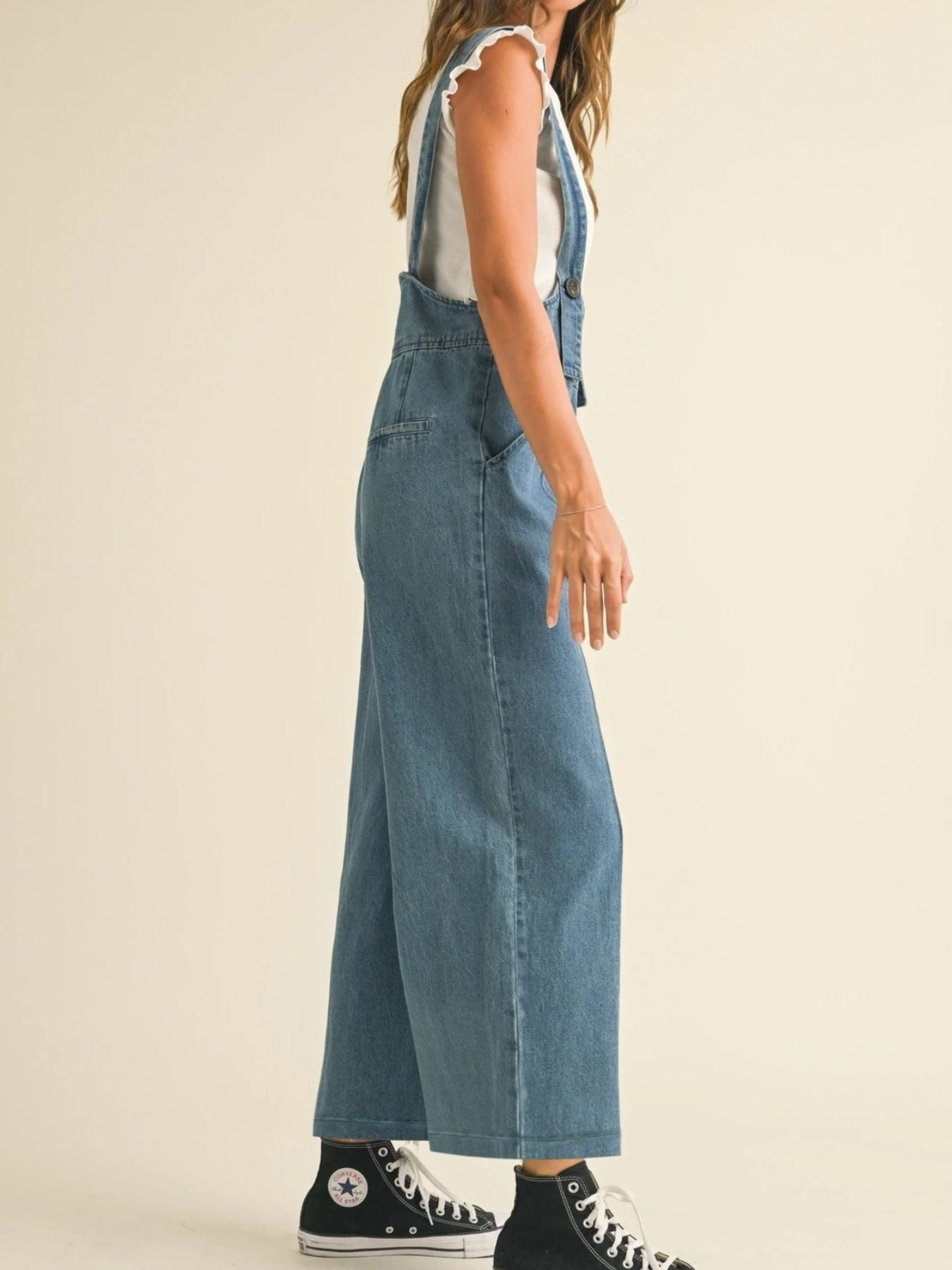 Vintage denim wide leg overalls with adjustable straps and button detail.