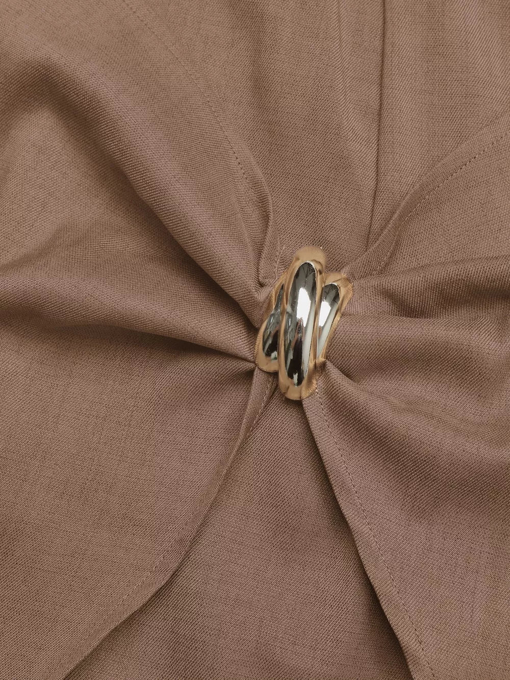 Brown twist-front skort with a decorative silver button detail.