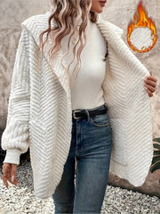 Ivory textured chevron hooded cocoon coat with open front, styled with jeans.