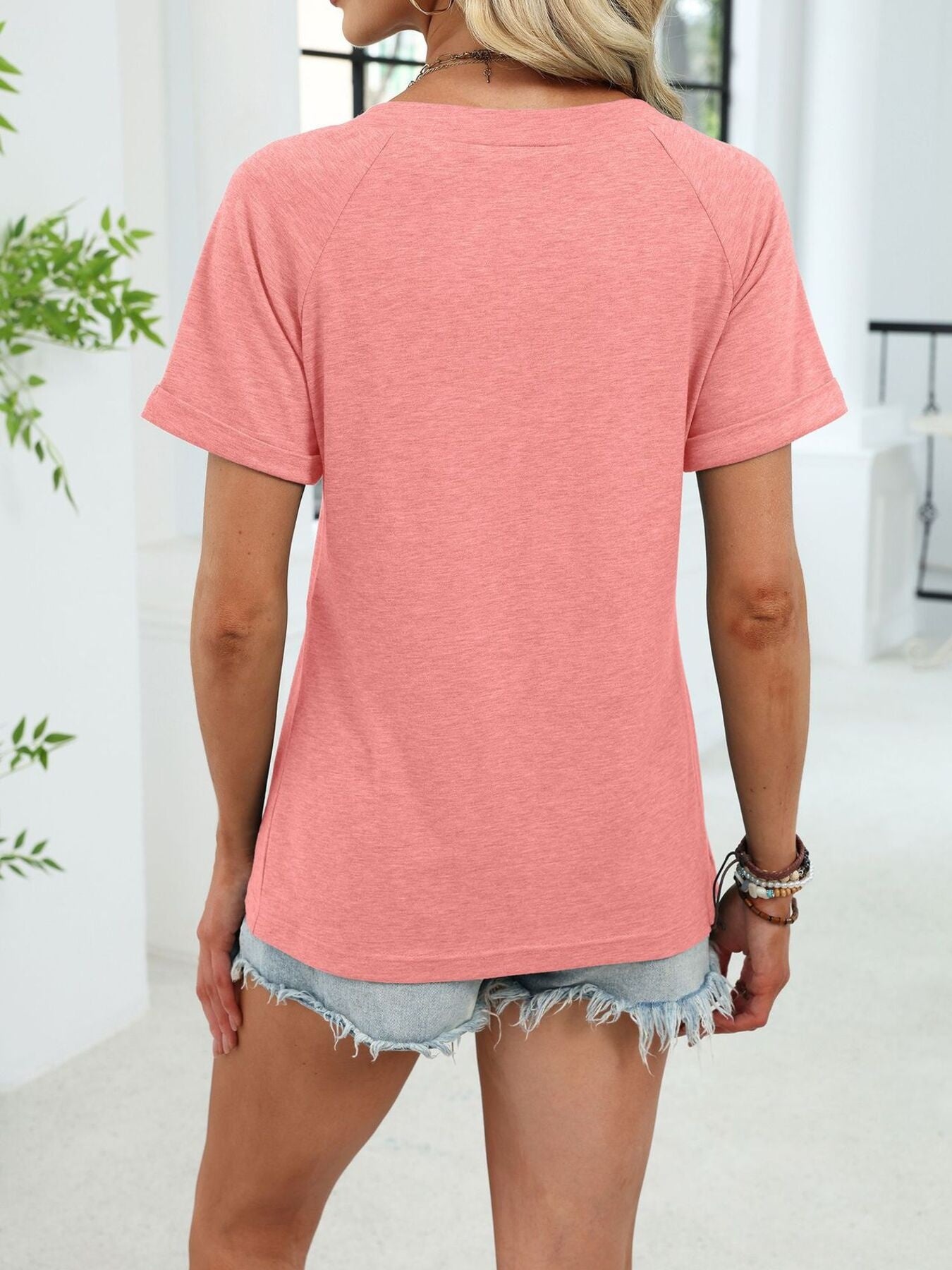 Pink ruched V-neck short sleeve t-shirt with elastane, styled with denim shorts.