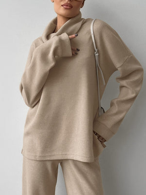 Beige cowl-neck turtleneck and pants set with relaxed fit and comfortable knit fabric.