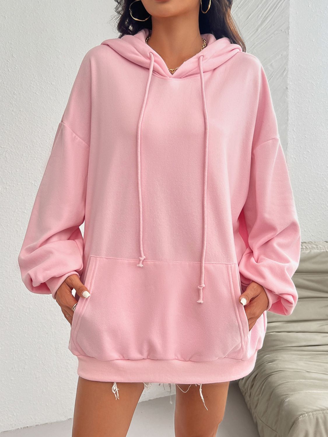 Oversized blush pink hoodie with drawstring detail and front pocket.
