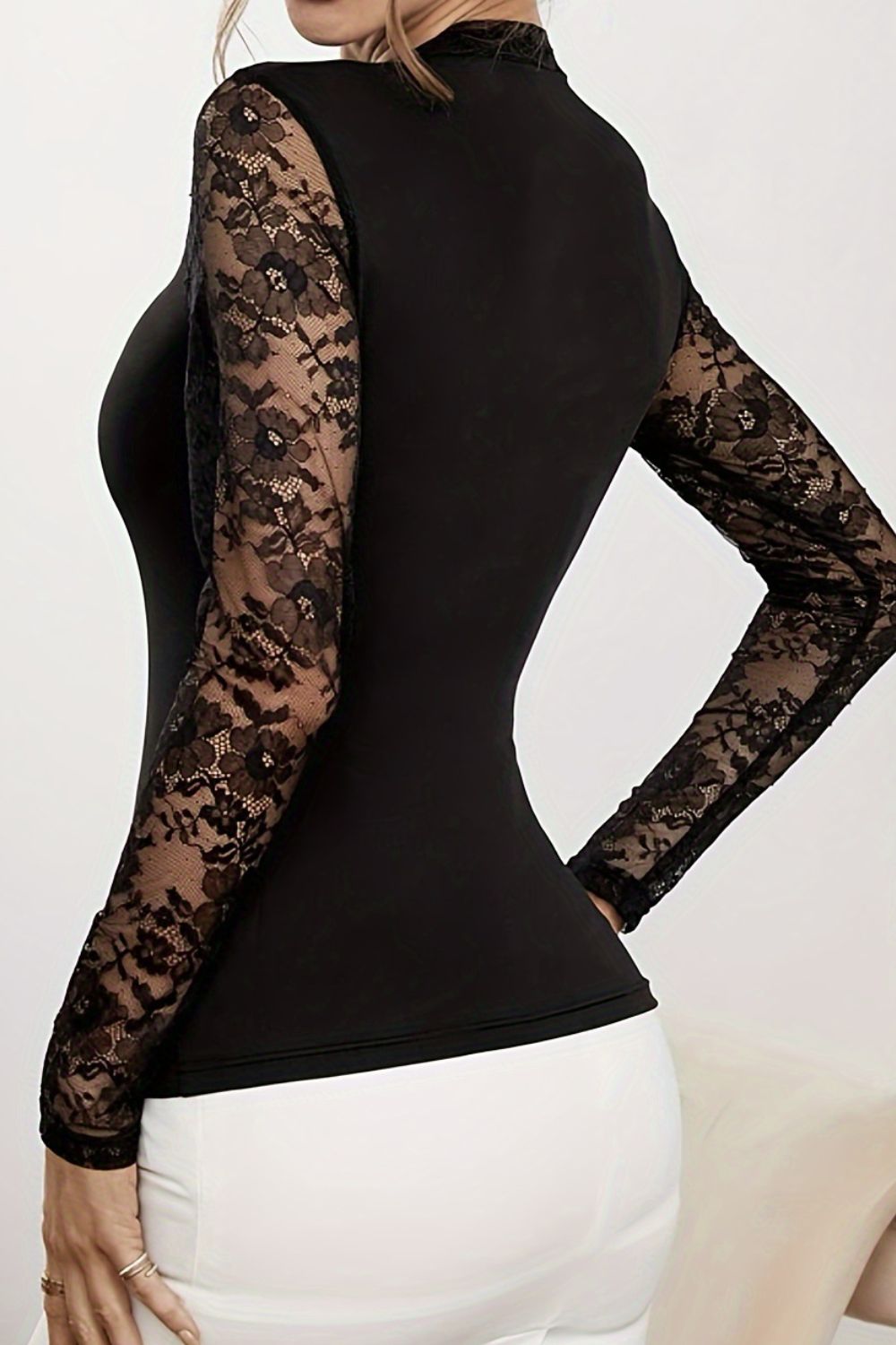 Black lace illusion bodysuit with long sleeves and a mock neck.